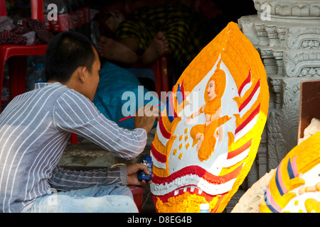 Man painting sur un panneau dans la rue à Phnom Penh, Cambodge Banque D'Images
