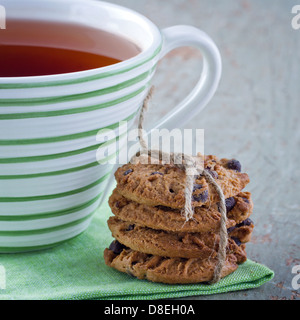Libre de cookies aux pépites de chocolat et une tasse de thé sur fond de bois vintage Banque D'Images