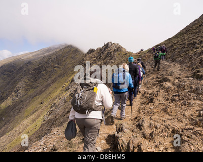 Randonneurs marche sur chemin sur Rhyd Ddu Bwlch à Snowdon principal avec vue sur le pic de enveloppée de nuages bas. Le Nord du Pays de Galles Snowdonia UK Banque D'Images