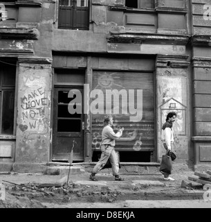 Berlin, RDA, les piétons à pied passé de maisons abandonnées Banque D'Images