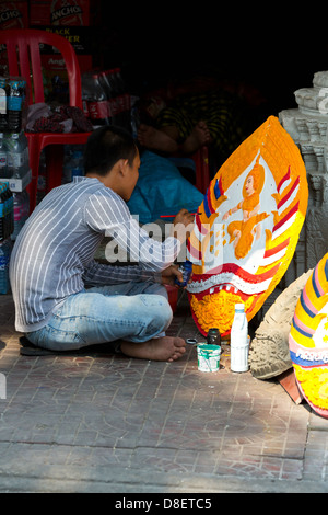 Man painting sur un panneau dans la rue à Phnom Penh, Cambodge Banque D'Images