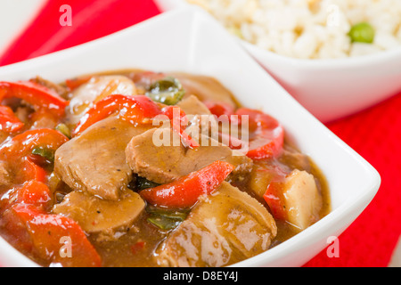 Style Chinois porc aux poivrons rouge servi avec riz frit à l'oeuf. Banque D'Images