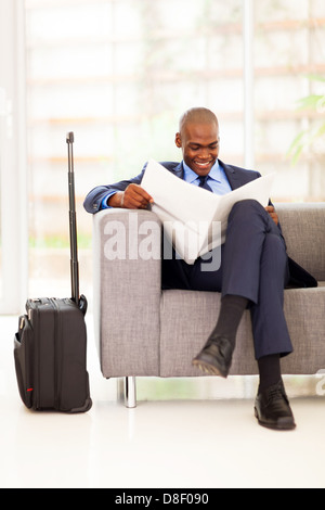 African businessman reading newspaper in airport lounge VIP Banque D'Images