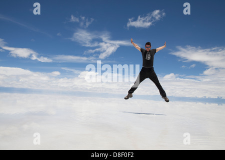 Homme passe dans le sombre paysage blanc du Salar de Uyuni en Bolivie Banque D'Images