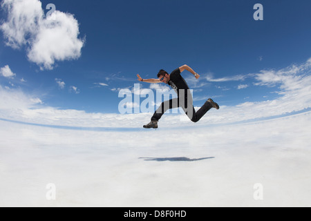 L'homme qui saute dans les airs avec des paysages de rêve (Salar de Uyuni) Banque D'Images