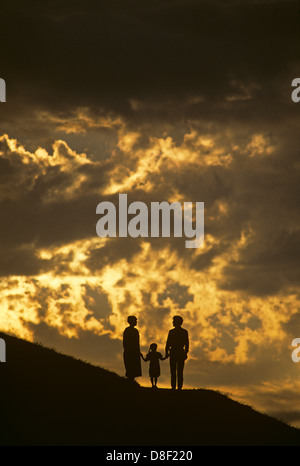 Famille sur colline tenant la main et face à la vie ensemble. Banque D'Images