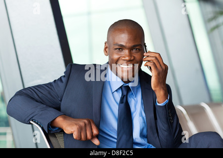 African Business Traveler talking on cellphone in airport Banque D'Images