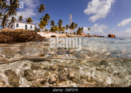 La photographie sous split shot de la vie marine et l'un deux siècle d'ancien phare au-delà de la réparation à Halfmoon Caye, Belize. Banque D'Images