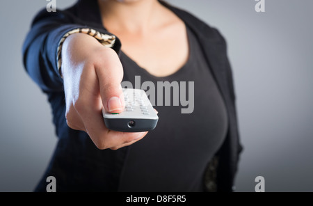 Femme est titulaire d'une commande à distance dans ses mains avec son corps n'est pas mise au point Banque D'Images