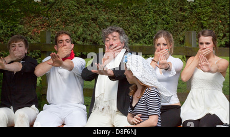 Production semi-pro de Godspell dans le jardin d'un pub Suffolk. Cinq personnes rejettent une mariée avec leurs mains au-dessus de leur bouche et tendues. Banque D'Images