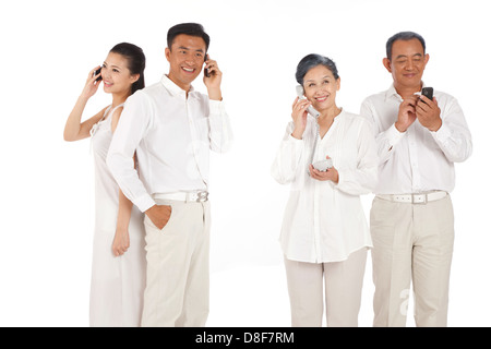 Vieux couple et jeune couple making phone call Banque D'Images