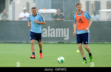 Miami, Floride, USA. 28 mai 2013. L'équipe nationale de football allemand Lukas Podolski et Per Mertesacker (R) à travers une eau de type sprinkleur pendant une session de formation à Barry University à Miami, Floride, USA, 28 mai 2013. L'équipe allemande est en tournée aux Etats-Unis avant le 03 juin. Photo : THOMAS EISENHUTH/dpa/Alamy Live News Banque D'Images