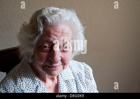 Portrait d'une femme âgée à la maison, souriant et regardant la caméra. Banque D'Images