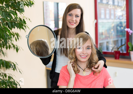 Coiffure client montre sa nouvelle coupe dans un miroir Banque D'Images