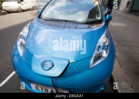 Une Nissan Leaf, une voiture électrique à une station de rechargement de la chaussée à Londres. Banque D'Images