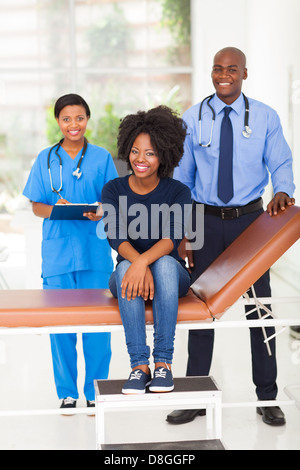 Jeune femme africaine dans le cabinet du médecin avec médecin et l'infirmier Banque D'Images