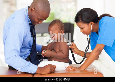 Afrique femme de l'assistant médical de l'examen d'un médecin avec bébé Banque D'Images