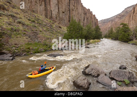 Un kayak gonflable pagaie vers le bas Maine's Bruneau River. Banque D'Images