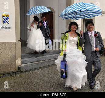 Couple de mariage chinois bleu et blanc bavarois hold parapluies qu'ils arrivent pour leur mariage dans le musée de la ville de Füssen, Allemagne, 29 mai 2013. Onze des couples provenant de la Chine ont renouvelé leurs vœux de mariage devant un Roi Ludwig II acteur. Photo : STEFAN UDRY Banque D'Images