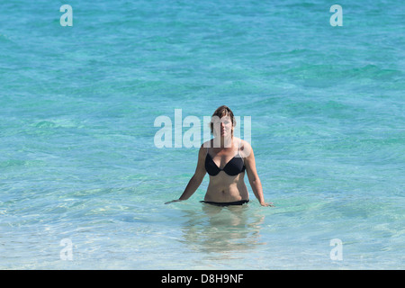 L'eau bleu tropical avec l'âge moyen noir maillot de bain femme Banque D'Images