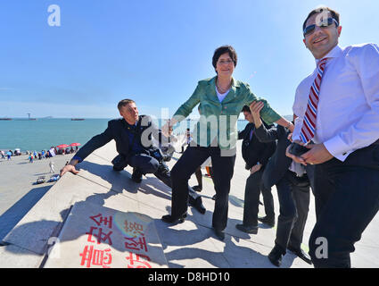 Premier Ministre du Land de Thuringe Christine Lieberknecht monte une structure avec l'aide d'autres personnes à regarder la promenade le long de la côte avec le secrétaire d'État Peter Zimmermann (R) à Dalian, Chine, 29 mai 2013. La Thuringe est le premier ministre visite en Chine avec une importante délégation jusqu'au 31 mai. Dans les discussions et réunions, la relations économiques et scientifiques devrait être renforcé et élargi. Photo : MARTIN SCHUTT Banque D'Images