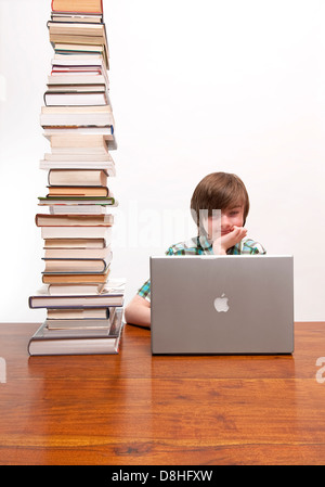 Jeune homme boy doing homework using laptop computer Banque D'Images