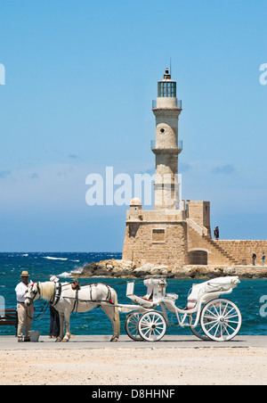 Cheval et sa voiture se trouve dans le port vénitien de Chania, dans phare en arrière-plan. Crète, Grèce. Banque D'Images