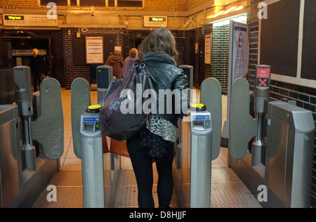 Un frontalier PASSE À TRAVERS LES OBSTACLES À UNE STATION DE MÉTRO SUR LE RÉSEAU DU MÉTRO DE LONDRES, UK Banque D'Images