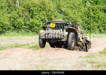 Overlord, D-Day re-enactment à Denmead 2013. Jeep américaine bondit hors d'un dip, les roues avant de quitter le terrain. Banque D'Images