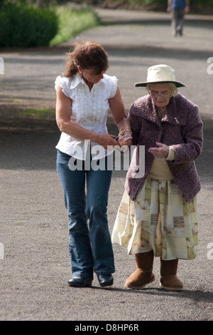 Femme marche avec dame âgée dans park Banque D'Images