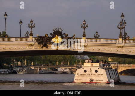 Paris, France. Un bateau de tourisme de la "Vedettes du pont neuf' company navigue sous l'or-orné pont Alexandre III. Banque D'Images