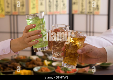 Trois personnes Toasting avec diverses Chu-Hi à Izakaya Banque D'Images