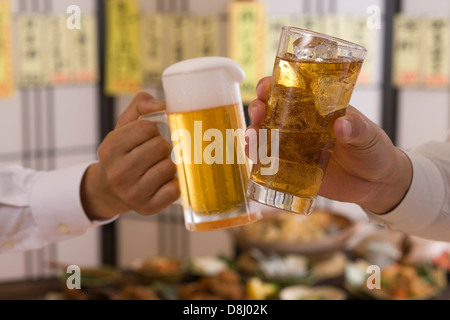 Deux personnes le grillage avec bière et Chu-Hi à Izakaya Banque D'Images