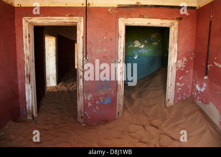 Le sable et les portes à l'intérieur de maison abandonnée, Kolmanskop Ghost Town, près de Lüderitz, Namibie, Afrique Banque D'Images