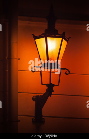 Vieux réverbère la lumière sur le mur dans la nuit. Tallinn, Estonie Banque D'Images