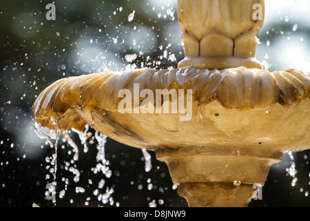 Close-up d'une vieille fontaine en pierre avec des gouttes d'eau et l'arrière-plan flou Banque D'Images