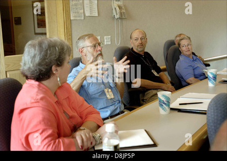 Un groupe de personnes est assis à une table, participant activement à une discussion de groupe pendant une réunion. Cet environnement collaboratif se retrouve généralement dans les milieux commerciaux, éducatifs ou organisationnels où les idées sont partagées et les décisions prises. Banque D'Images