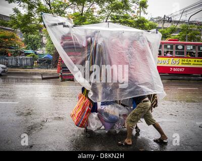 31 mai 2013 - Bangkok, Thaïlande - un homme pousse un rack de vêtements à travers la pluie pour Bobae Market à Bangkok. Bobae est un marché de 30 ans, célèbre pour la mode et la vente en gros est maintenant très populaire avec les exportateurs du monde entier. Bobae Tower se trouve à côté du marché et s'annonce comme ayant 1 300 cale sous un même toit et prétend être le plus grand centre de vente en gros en Thaïlande. (Crédit Image : © Jack Kurtz/ZUMAPRESS.com) Banque D'Images