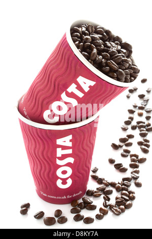 Deux tasses de café Costa avec des haricots frais sur fond blanc Banque D'Images
