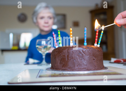 L'éclairage des bougies sur un gâteau d'anniversaire Banque D'Images