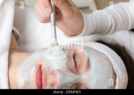 Cosmetician appliquant soin du visage masque pour client Banque D'Images