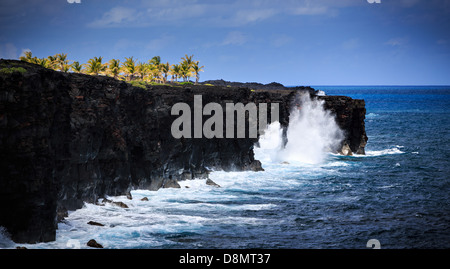 Les vagues déferlent le long des falaises de roche de lave noire dans le Parc National des Volcans d'Hawaï. Cette vue est à la fin de la chaîne des cr Banque D'Images