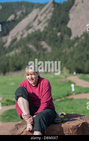 Randonneur femme frotte blessé à la cheville. Banque D'Images