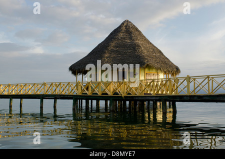 Bungalow au toit de chaume sur pilotis au lagon à Punta Caracol Hotel Banque D'Images