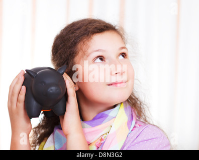 Petite fille d'économiser de l'argent dans une tirelire Banque D'Images