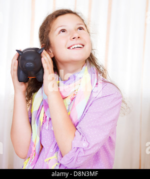 Petite fille d'économiser de l'argent dans une tirelire Banque D'Images