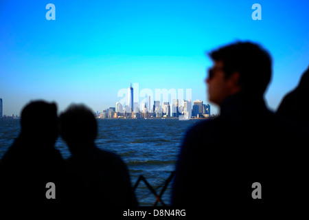 Les passagers à bord du ferry pour Staten Island regarder la vue sur l'horizon de Manhattan, New York. Banque D'Images