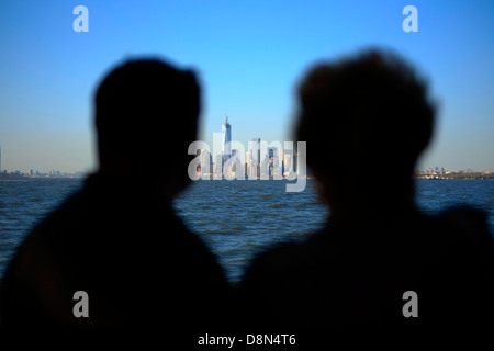 Les passagers à bord du ferry pour Staten Island regarder la vue sur l'horizon de Manhattan, New York. Banque D'Images