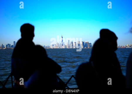 Les passagers à bord du ferry pour Staten Island regarder la vue sur l'horizon de Manhattan, New York. Banque D'Images