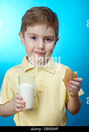 Petit garçon mange des pie et verre de lait Banque D'Images